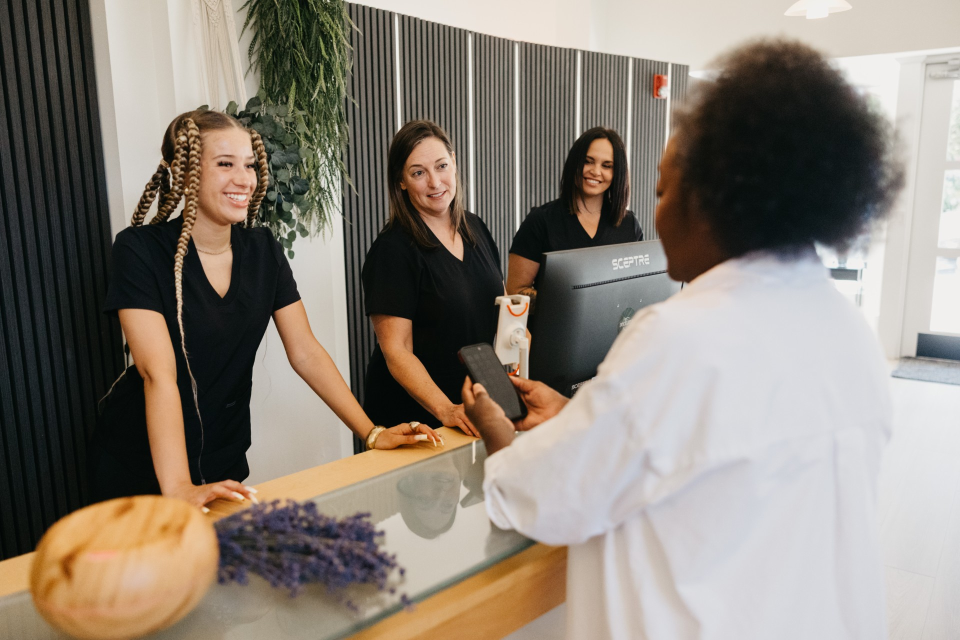 The Recharge PNW team welcoming a member at the front desk in Everett